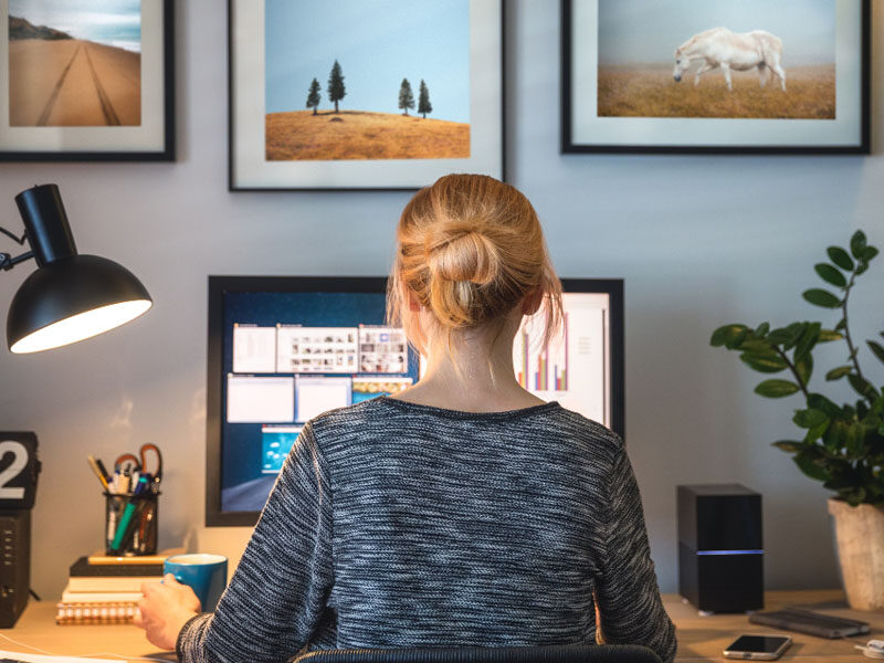 A woman sitting at her desk working from home.